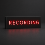 Black resin recording sign with thin red illuminated lettering